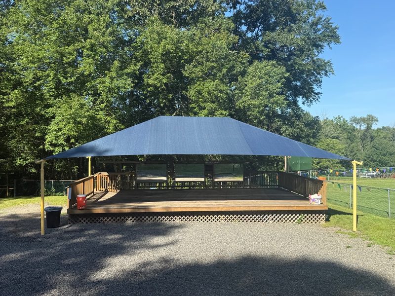 Blue shade canopy over a raised wooden deck