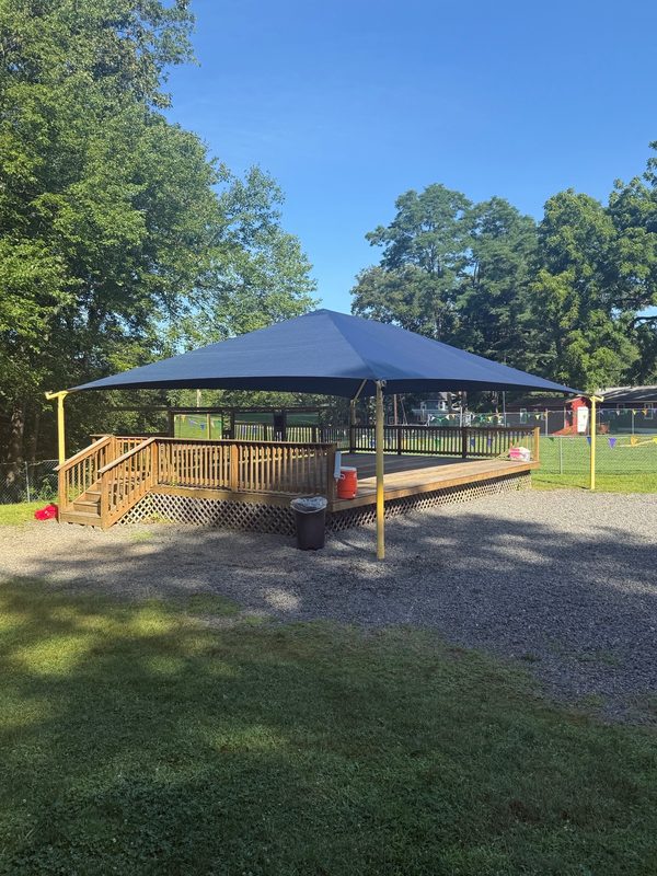 Blue shade canopy over a raised deck with ramp