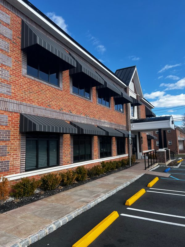 Striped window awnings along a brick office building
